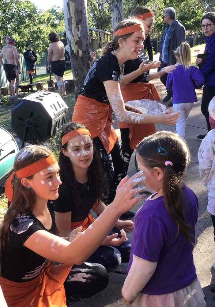 Visit from local Aboriginal dance group, painting faces of children at preschool